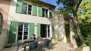 un tavolo e delle sedie davanti a una casa di Kleine Auszeit (Petite Pause) a Grimaud