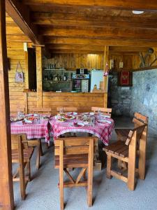 ein Esszimmer mit Tischen und Stühlen sowie eine Küche in der Unterkunft Etno selo ŽURIĆ in Mojkovac