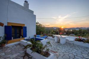 a house with a patio with a sunset in the background at Secret Garden, a little paradise of tranquility. in Lépidha