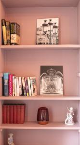 a shelf with books and a picture of a lamp at Stylish Luxury 2-Bed Serviced Apartment in Heart of West End SSE Hydro Botanic Gardens in Glasgow