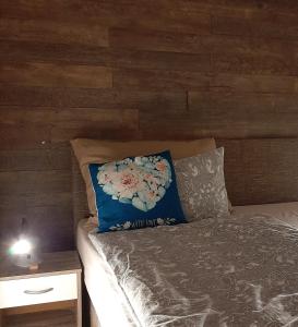 ein Bett mit einem blauen Kissen und einem Nachttisch in der Unterkunft Best Relax Hévíz Apartman in Hévíz