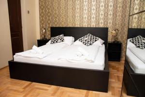 een zwart bed met witte lakens en kussens erop bij Andrassy Room in Boedapest