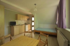 a room with a table and a kitchen with a dining room at Willa Morskie Oko in Gdańsk