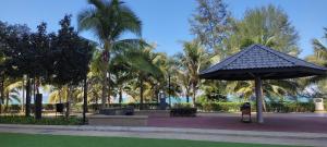 a park with a large umbrella and palm trees at Studio with Privacy Balcony and NETFLIX at TimurBay Sea Front Residence in Kuantan