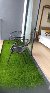 a table and a chair on a green rug in a room at Studio with Privacy Balcony and NETFLIX at TimurBay Sea Front Residence in Kuantan