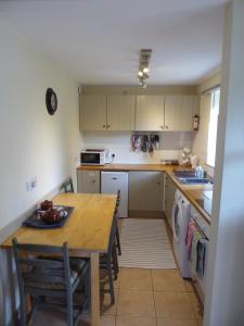 a kitchen with a wooden table and a dining room at Mews Cottage in Middleton in Teesdale