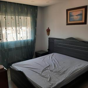 艾尔亚奈bel appart terasse vue panoramique avec piscine的带床和窗户的卧室