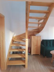a staircase in a living room with a blue couch at Chata nad Rzeką in Lipusz