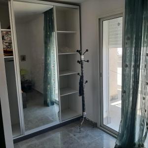 艾尔亚奈bel appart terasse vue panoramique avec piscine的一间设有镜子的房间,窗户旁设有三脚架