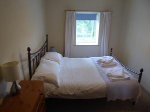 a bedroom with a large bed with a window at Mews Cottage in Middleton in Teesdale