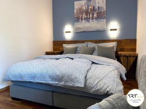 a bedroom with a bed with blue sheets and pillows at ARTtrend Luxury Villa in Tihany