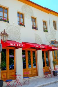 um edifício com um toldo vermelho em frente a um restaurante em Tebeu coffe and bar em Vlorë
