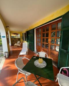 um pátio com uma mesa e cadeiras num alpendre em Rocca di Corno Guest House em Finale Ligure