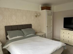 a bedroom with a bed and a flat screen tv at Greenacre House close to Liverpool John Lennon Airport in Woolton