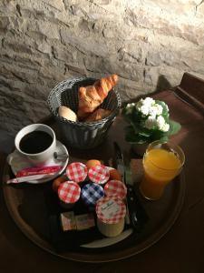 un vassoio con prodotti per la colazione e un cesto di pane e caffè di L'étape du château a Bruniquel
