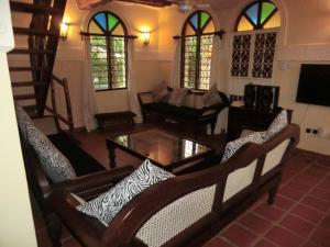 una sala de estar con una mesa y sillas en Villa Lamuhouse Diani Beach, en Diani Beach