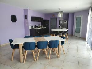 a dining room with white tables and blue chairs at villa 15 personnes avec piscine et terrain de pétanque in Puysserampion