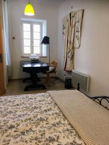 1 dormitorio con cama, escritorio y piano en Maison agréable avec vue splendide, en Monze