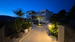 a house with a lot of plants and lights at Apartment Lea in Trogir