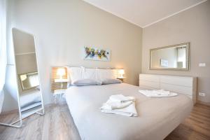 una camera da letto con un grande letto con due asciugamani bianchi di Top Living Apartments - Appartamenti Saluzzo a Torino