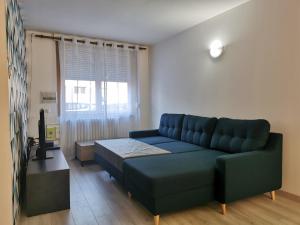 a living room with a blue couch and a television at La cosy house Tourcoing in Tourcoing