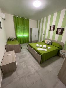 a bedroom with two beds and a green and white stripes at Le Camere Del Villaggio in Agrigento