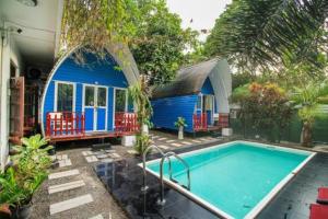 una casa azul con piscina en un patio en A4 Residence Colombo Airport -by A4 Transit Hub - free pickup & drop Shuttle Serviceトランジットホテルトランジットホテル, en Katunayake