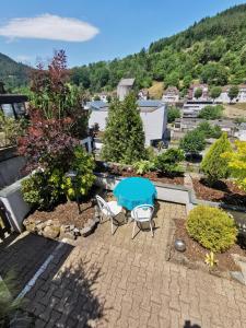 Blick auf eine Terrasse mit einem blauen Tisch und Stühlen in der Unterkunft Terrassenwohnung mit toller Aussicht & zentrumsnah in Hornberg