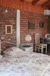 a bedroom with a bed and a brick wall at Studio Apartment Romeo in Velika Gorica