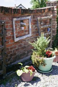 a brick wall with two potted plants and a mirror at Studio Apartment Romeo in Velika Gorica
