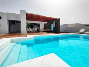 a large blue swimming pool in a house at Villalia Aroa in Playa Blanca