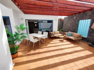 uma sala de estar com uma mesa e cadeiras e uma mesa e uma mesa em Villalia Aroa em Playa Blanca