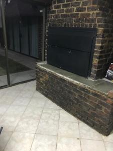 a brick wall with a television on top of it at Pomona Lodge in Kempton Park