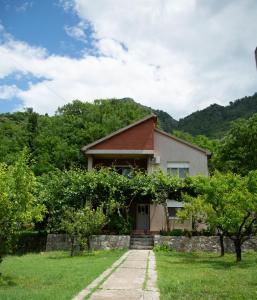 a house in the middle of a field with trees at Flamingo in Virpazar