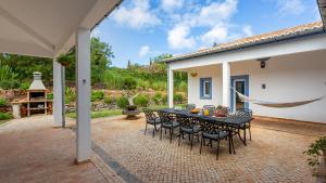 a patio with a black table and chairs at Luxury Villa With Pool in Vineyard Near the Beach in Porches