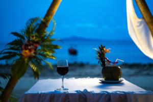 a glass of wine sitting on a table on the beach at Phi Phi Relax Beach Resort in Phi Phi Islands