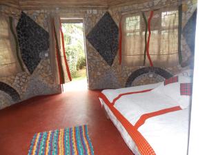 a bedroom with a bed in a room with a window at Songota Falls Lodge in Arusha
