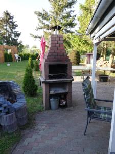 Vorder BollhagenにあるFerienwohnung Margareteの庭にあるレンガ造りの屋外オーブンと椅子