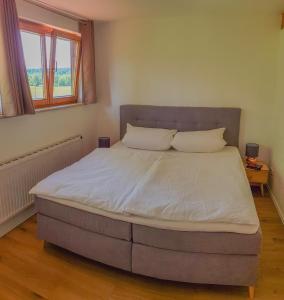 1 dormitorio con 1 cama grande con sábanas y almohadas blancas en Ferienwohnung Hehl, en Burgberg