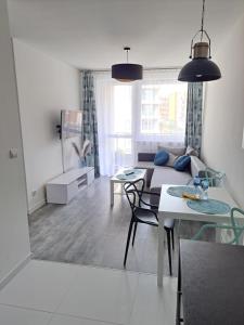 sala de estar con sofá y mesa en Apartament Morski, en Koszalin