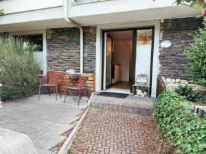 uma casa com um pátio com uma mesa e cadeiras em Casa Schneider - Urlaub an der Mittelmosel em Enkirch