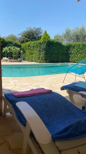a pool with two lounge chairs and a blue blanket at 2 Pièces Rdc Villa Piscine in La Roquette-sur-Siagne