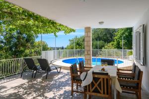 une terrasse avec une table et des chaises ainsi qu'une piscine dans l'établissement Apartment MARIO - veliki stan za odmor - terasa- vrt - bazen - pogled more, izoliran, à Orašac