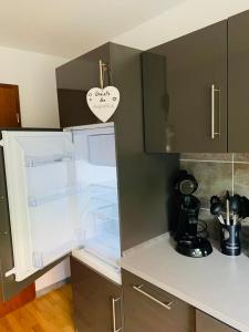 eine Küche mit einem offenen Kühlschrank mit einem Herz an der Tür in der Unterkunft Im Süden in Ettenheim