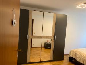 Schlafzimmer mit Glasschiebetür und Spiegel in der Unterkunft Im Süden in Ettenheim