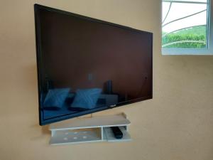 telewizor z płaskim ekranem wiszący na ścianie w obiekcie MAS VALLCROSA Chambre suite parentale avec jardin et piscine w mieście Camélas