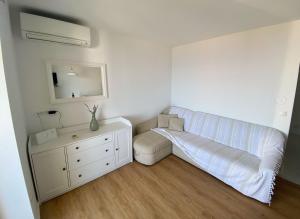 a living room with a white couch and a dresser at Apartment Ornela in Ravni