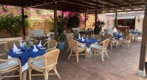 an outdoor restaurant with blue tables and chairs at Hotel Restaurant Baladrar in Benissa