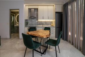 a kitchen with a wooden table and green chairs at Mansion House Parga in Parga