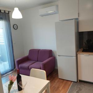Apartment Paola with free private parking place في سبليت: غرفة معيشة مع أريكة أرجوانية وطاولة